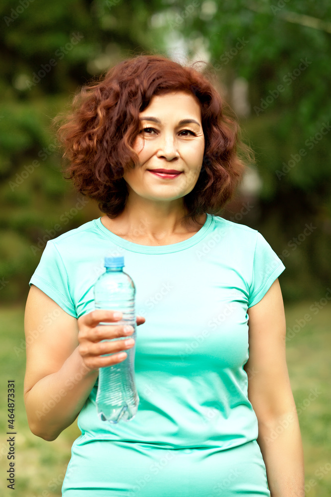 Middle age senior runner woman drinking bottled water after fitness exercise outdoors Middle age senior runner woman drinking bottled water after fitness exercise outdoors