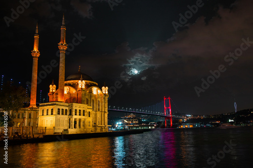 Ortaköy Mosque and Bosphorus Bridge during blue hour, full moon and blue night Sky. One of the most popular locations on the Bosphorus, Istanbul, Turkey.