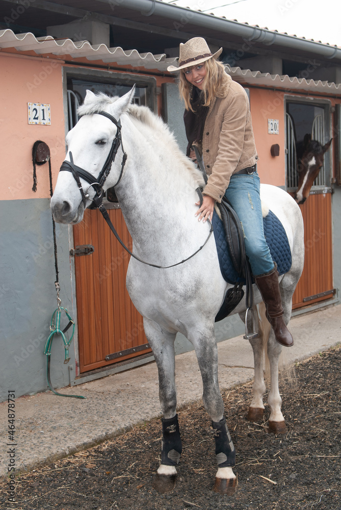 female rider in the stables mounted on horseback before going out for a jog