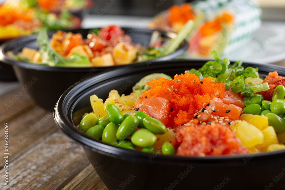 A closeup view of several customized poke bowls in a row.