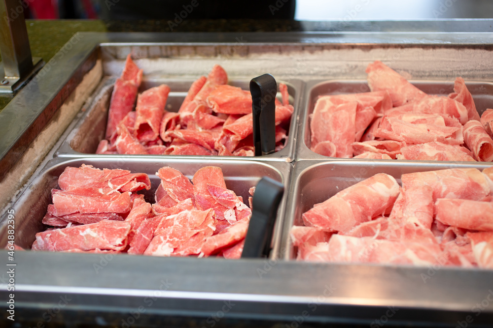 A view of a metal pans full of frozen beef slices, seen at a local Mongolian BBQ restaurant.