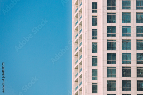 Wall With A Balcony Of New Empty Modern Multi-storey Residential Building House In Residential Area On Sunny Blue Sky. Close Up © Grigory Bruev
