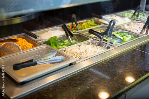 A view of a steamer pan filled with a variety of raw ingredients, seen at a local Mongolian BBQ buffet restaurant.