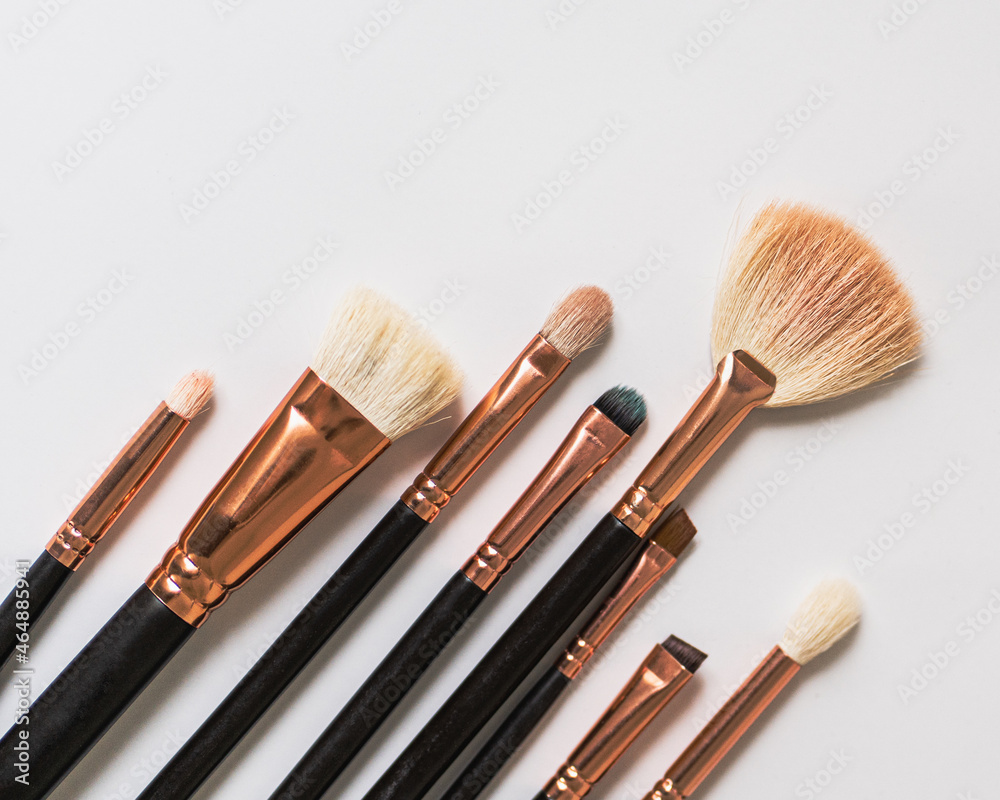 set of black makeup brushes laid out diagonally on a white table set of black makeup brushes laid out diagonally on a white table