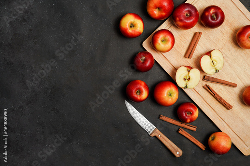 Fresh red apples with cinnamon on a black background. Apple baking seasonal concept. Fruits. Top view. Free space for text.