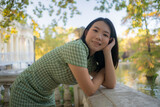 lifestyle portrait of young happy and attractive Asian Chinese woman relaxed taking a walk on city park enjoying Autumn nature during weekend getaway