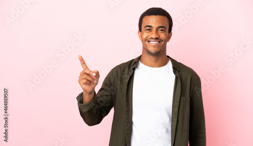 African American man on copyspace pink background pointing up a great idea