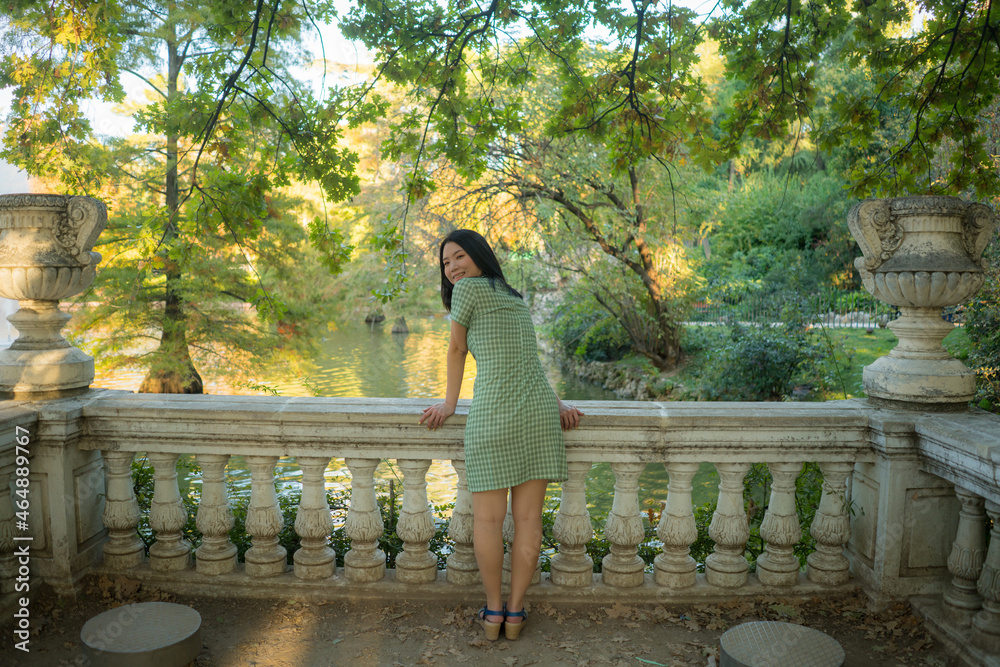 Naklejka premium lifestyle portrait of young happy and attractive Asian Japanese woman relaxed taking a walk on city park enjoying Autumn nature during weekend getaway