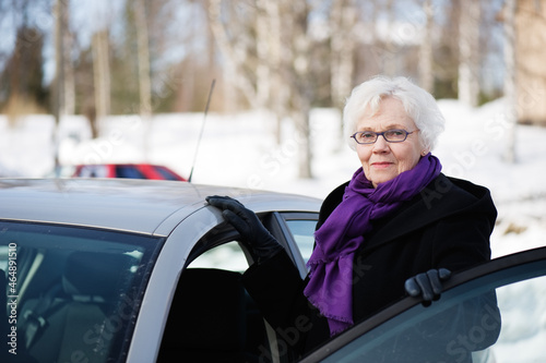 Stylish senior woman standing beside her car.