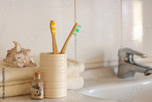 Cockleshell, Bath white cotton towels and bamboo toothbrushes on Blurred bathroom interior background with sink and faucet
