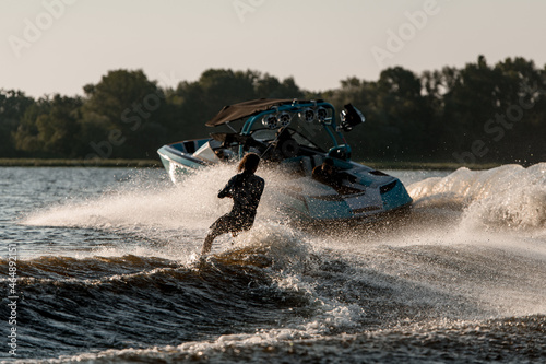 Cuadro en lienzo Bright motor boat pulls an active guy riding a wakeboard