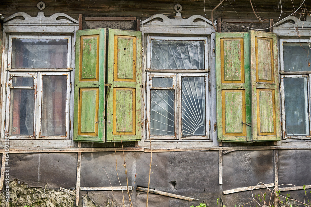 Windows with shutters on the old wooden house