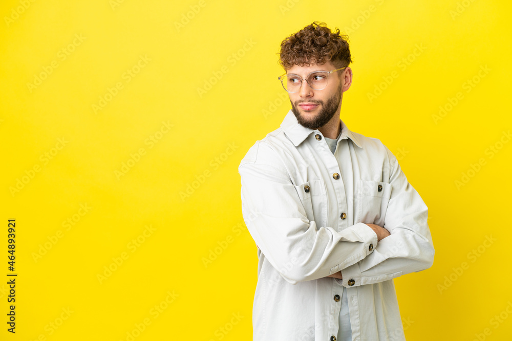 Young handsome caucasian man isolated on yellow background keeping the arms crossed Young handsome caucasian man isolated on yellow background keeping the arms crossed