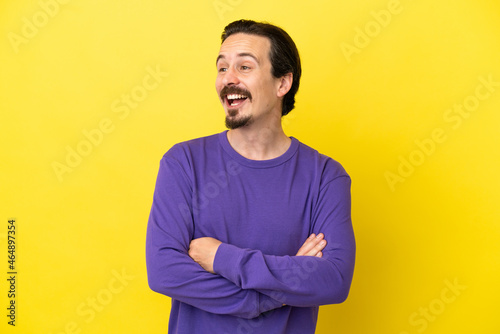 Young caucasian man isolated on yellow background happy and smiling
