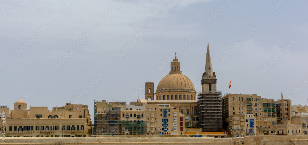 Fototapeta premium Coastal landscape of Valletta at sunny summer day, with its traditional architecture of yellow limestone. Maltese Valletta skyline with church of Our Lady of Mount Carmel and St Paul's Pro-Cathedral.