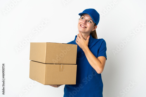 Young delivery woman isolated on white background looking up while smiling © luismolinero