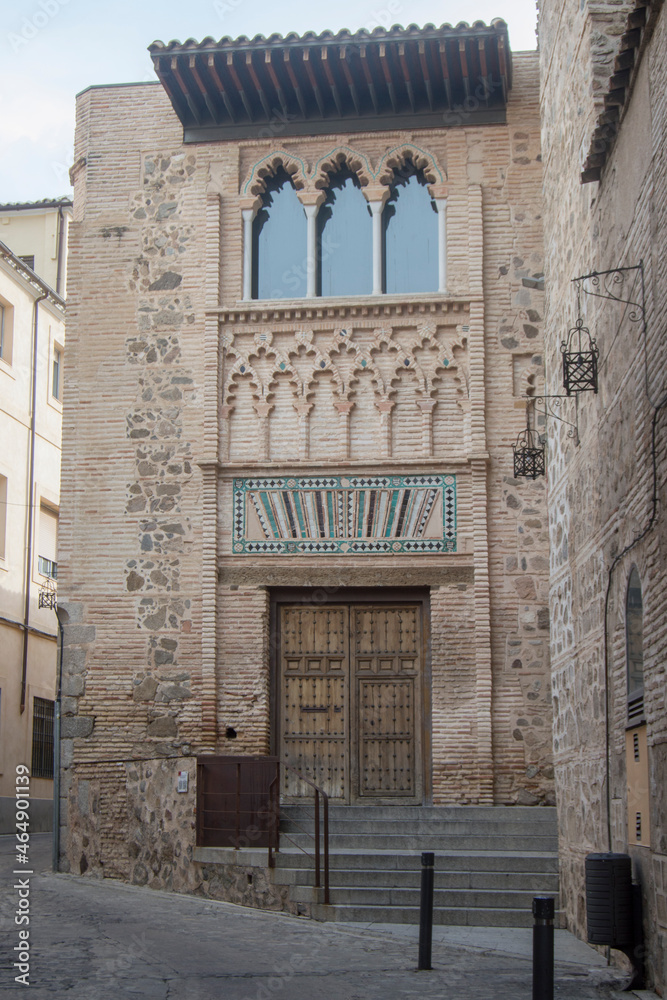 brick university façade and blind polylobed arches and a large window in Toledo. Spain