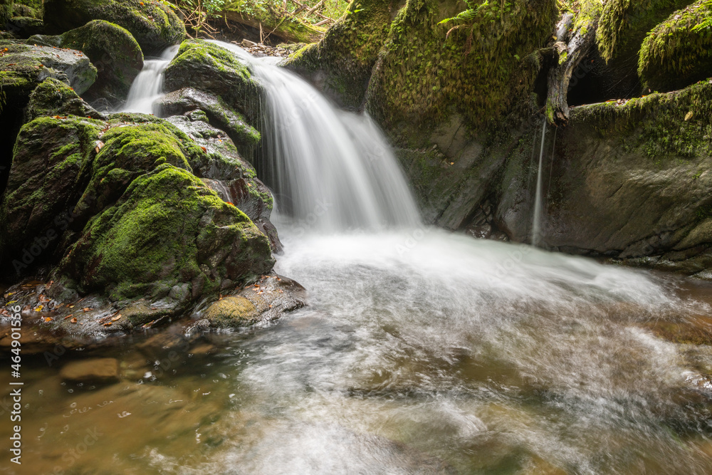 Long exposure of a waterfall on the Hoar Oak Water river flowing through the woods at Watersmeet in Exmoor National Park