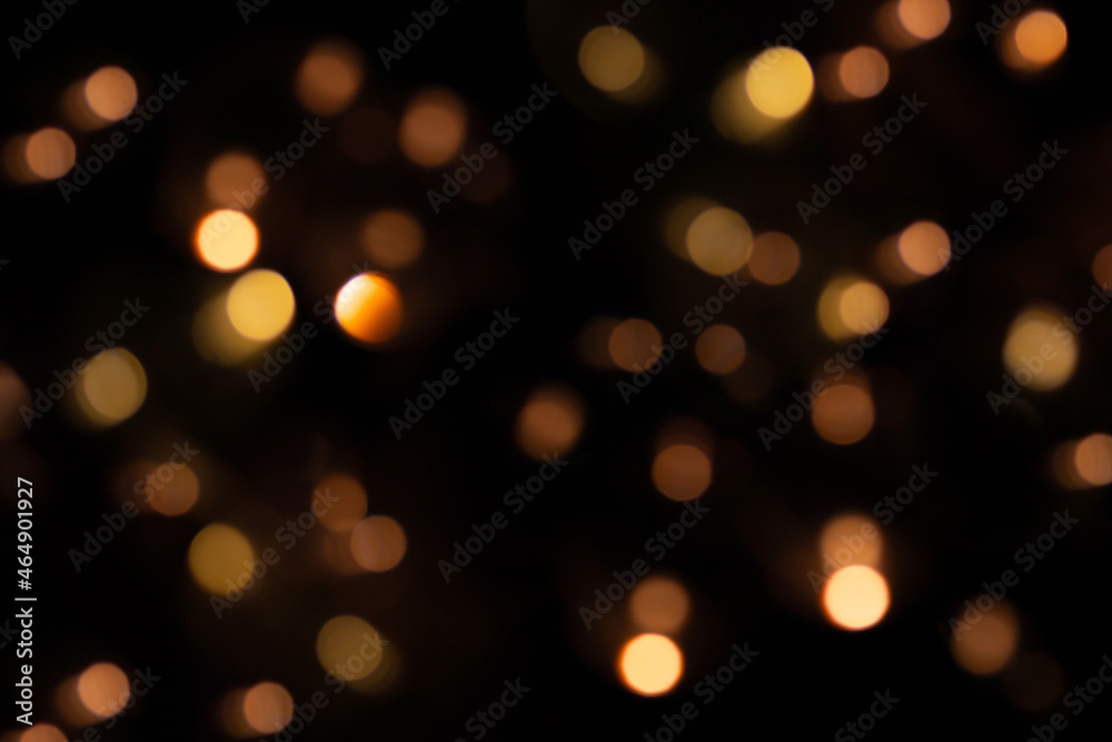 Defocused bokeh lights on black background, an abstract naturally blurred backdrop for Christmas eve or birthday party. Festive light texture. Yellow and red garland in blur. Overlay effect for design Defocused bokeh lights on black background, an abstract naturally blurred backdrop for Christmas eve or birthday party. Festive light texture. Yellow and red garland in blur. Overlay effect for design