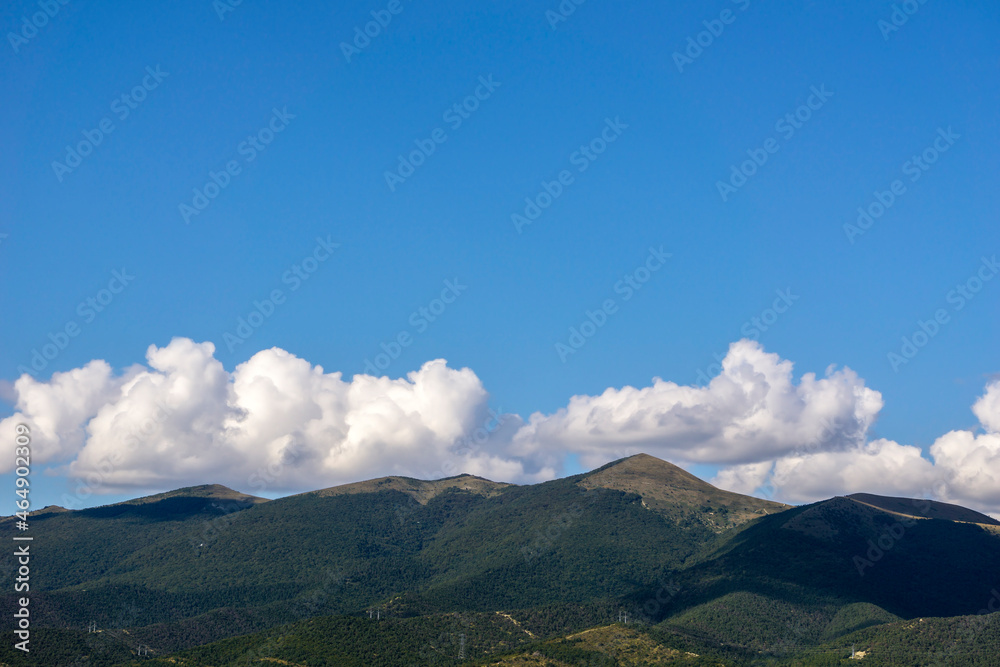 Mountains of the North Caucasus against the blue sky with clouds.