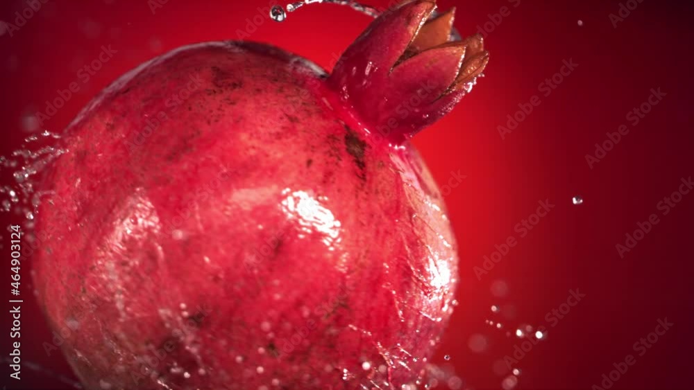Super slow motion water drips on rotating pomegranate . On a black background. Super slow motion water drips on rotating pomegranate . On a black background.