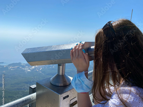 Woman on vacation looking through binoculars