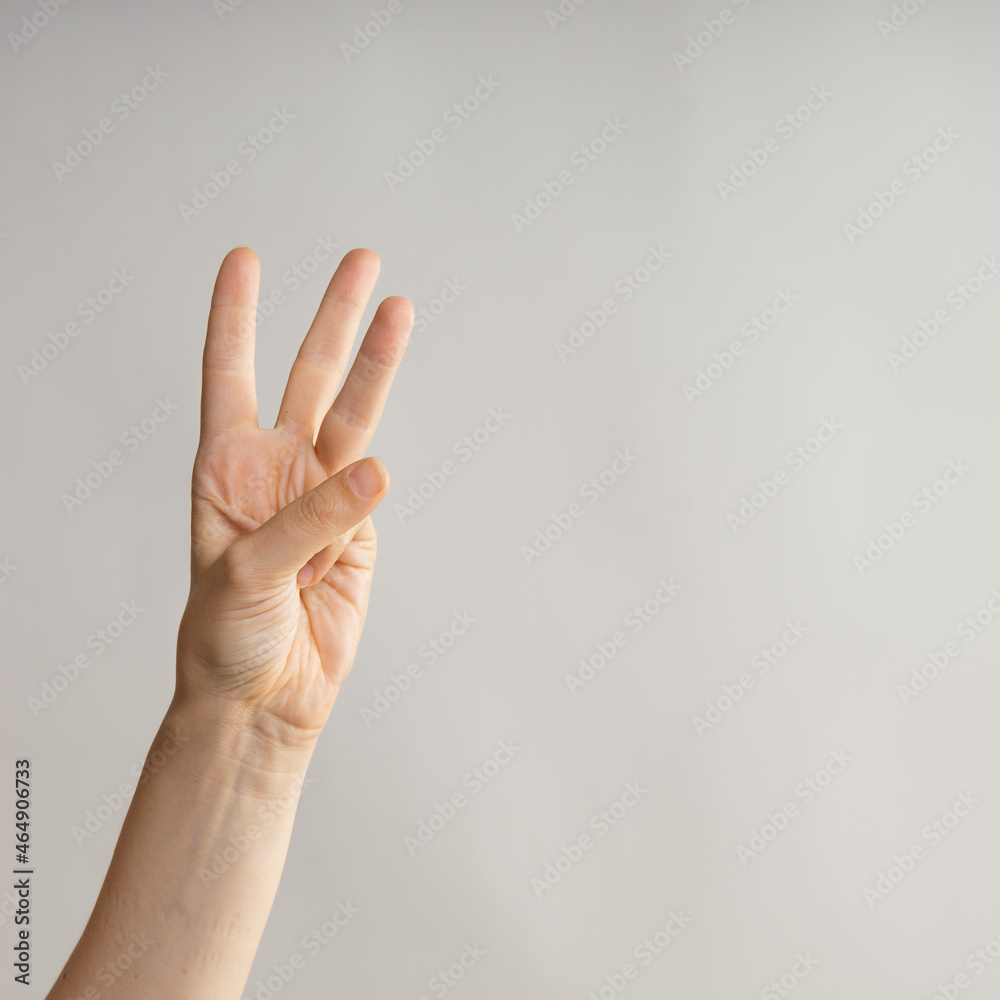 Hand gestures. woman's hand, three fingers up. Countdown, number three on your fingers. Hand gestures. woman's hand, three fingers up. Countdown, number three on your fingers.