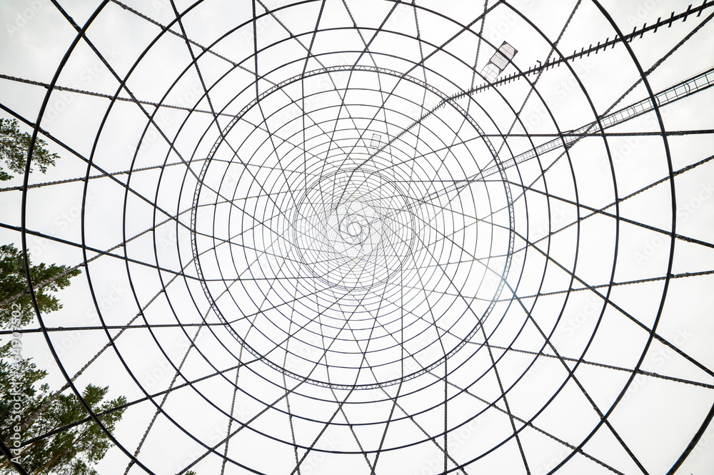 Obraz premium Bottom-up view of the Shukhov Tower on the Oka River, Nizhny Novgorod region, Russia. A beautiful web of metal structures and small.