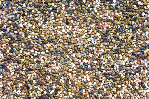 Texture of a brown ceramic stones. Ridge brown background of a facade. Ceramic surface. Texture from small colored darkly pebble. Mosaic flooring, colored stones.