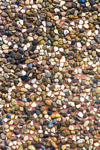 Texture of a brown ceramic stones. Ridge brown background of a facade. Ceramic surface. Texture from small colored darkly pebble. Mosaic flooring, colored stones.