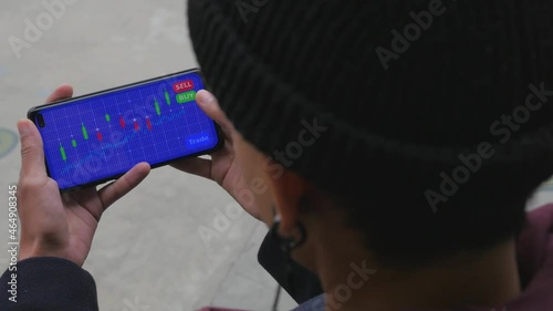 Young female analyzes a cryptocurrency stock market chart on her mobile phone