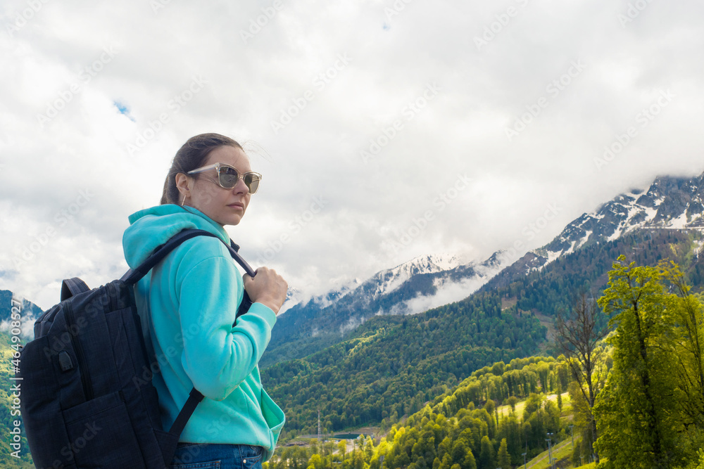 Local tourism, nature reserves and national parks. A young woman in a blue hoodie with a backpack Local tourism, nature reserves and national parks. A young woman in a blue hoodie with a backpack