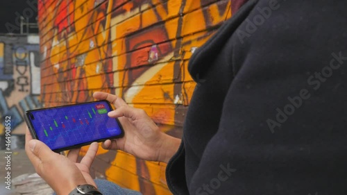 Young female analyzes a cryptocurrency stock market chart on her mobile phone