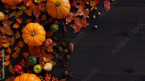 Thanksgiving Wallpaper with Fall leaves, Gourds and Acorns on a Dark wood Tabletop. photo