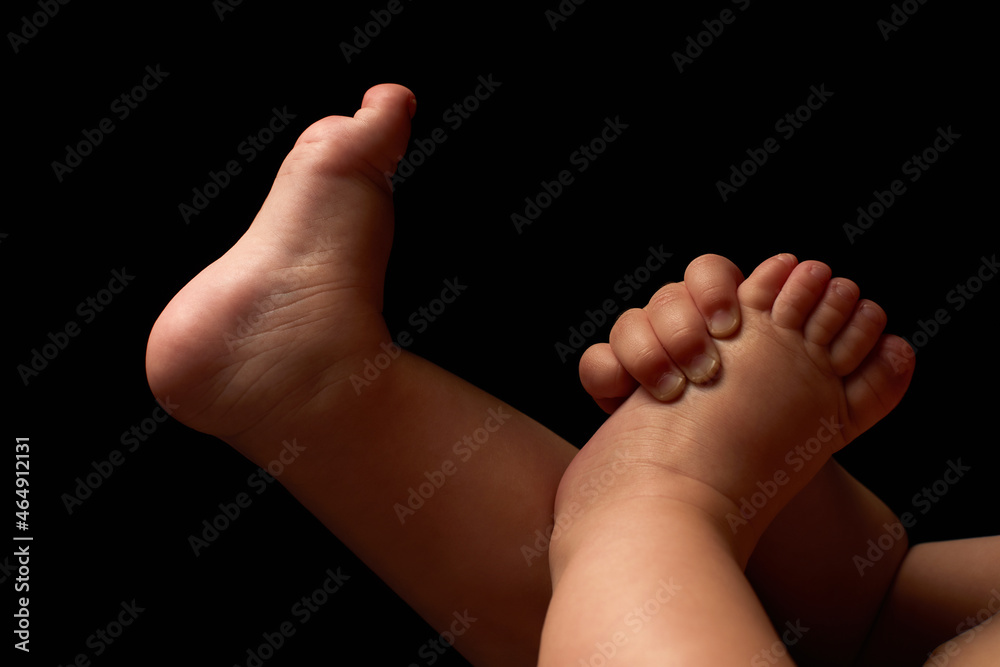 Close up newborn fingers feet and hands isolated on black background Close up newborn fingers feet and hands isolated on black background