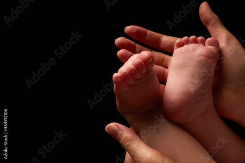 Close up newborn fingers feet and hands isolated on black background 