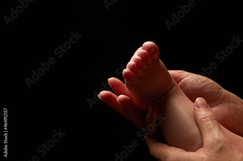 Close up newborn fingers feet and hands isolated on black background  © Naz