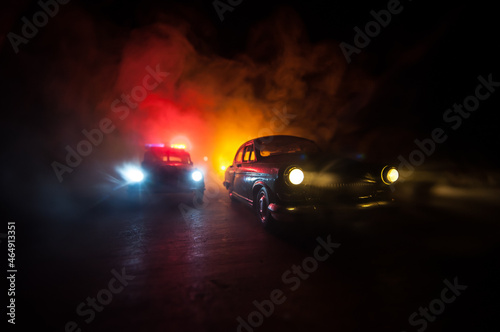 Police car chasing a car at night with fog background. 911 Emergency response police car speeding to scene of crime. © zef art