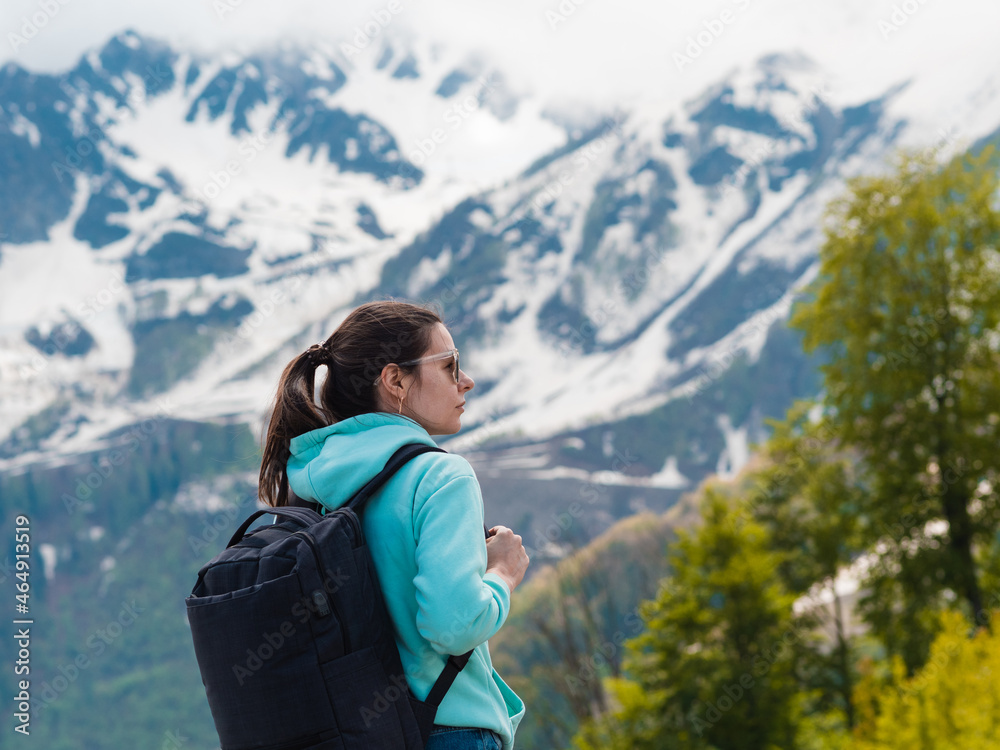 Local tourism, nature reserves and national parks. A young woman in a blue hoodie with a backpack