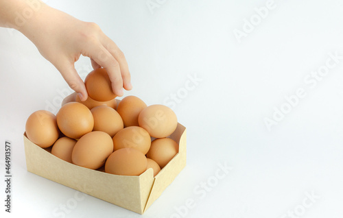 Box of frsh eggs isolated on a white background and a hand holding it photo