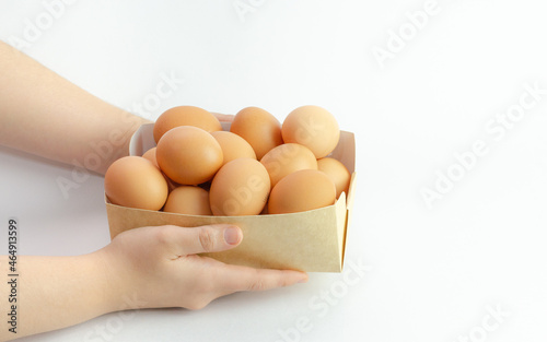 Box of frsh eggs isolated on a white background and a hand holding it photo