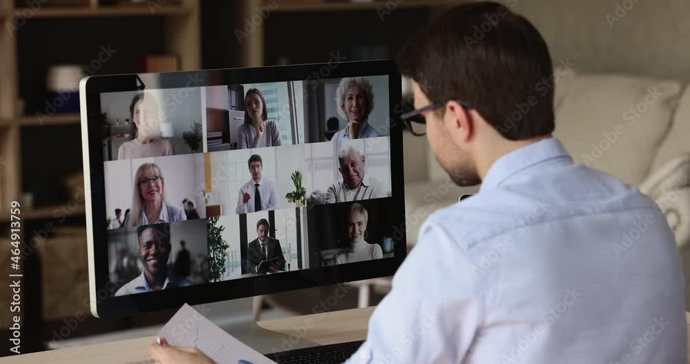 Virtual briefing. Over shoulder view male worker meet with leader colleagues by pc screen discuss sales at video conference mode. Young man remote employee work online communicate with business team