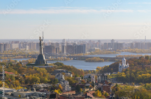 Beautiful panorama of autumn Kiev. View from the left bank to the Dnieper. Wide river in the city and autumn yellow trees.Village and city