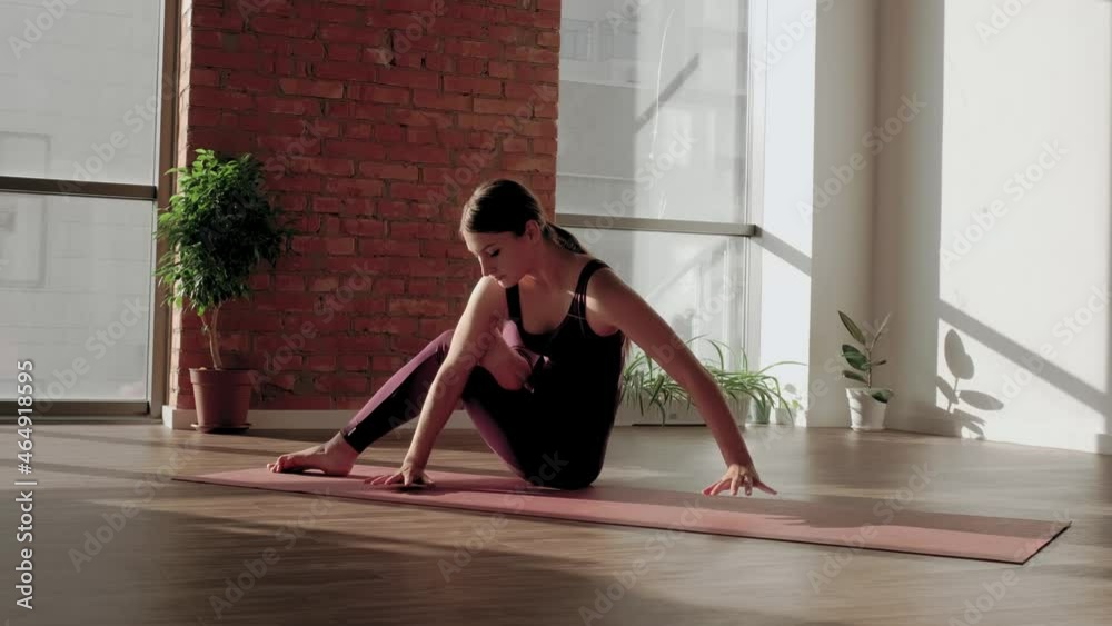 Young woman in red sports uniform performs the Astavakrasana asana in yoga studio. Balance exercise. Straddle press handstand and Stretching on mat while practicing. High quality 4k footage Young woman in red sports uniform performs the Astavakrasana asana in yoga studio. Balance exercise. Straddle press handstand and Stretching on mat while practicing. High quality 4k footage