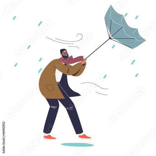 Man struggle with wind holding umbrella in rainy autumn day. Male suffer from rain outdoors