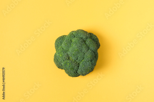 Top view fresh green broccoli vegetable on yellow. Broccoli cabbage head on a colored background. Flat lay. Copy space. Healthy or vegetarian food concept