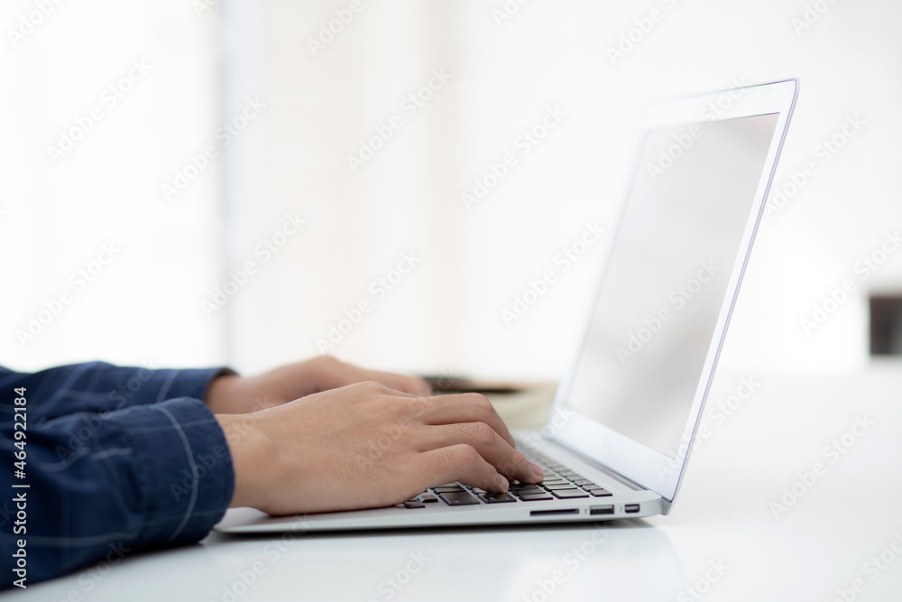 Hand of business man working from home using laptop computer to internet online on desk, lifestyle of new normal, social distancing, freelance work in stay home, employee using notebook indoor. Hand of business man working from home using laptop computer to internet online on desk, lifestyle of new normal, social distancing, freelance work in stay home, employee using notebook indoor.
