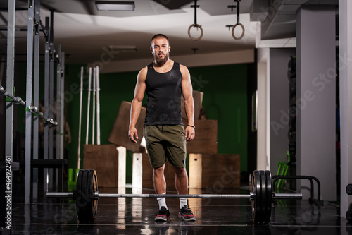 Athlete preparing for weightlifting. Muscular man posing in fitness studio