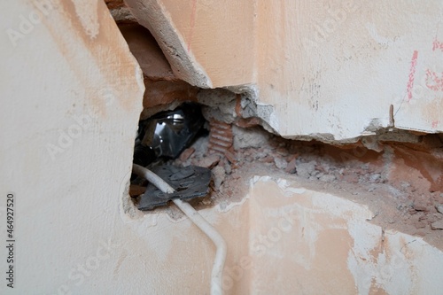 Home demolition. Hole in a wall showing the electricity conduit pass. Moving the eletrical points to new positions photo