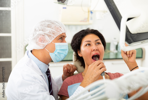 Dentist uses modern equipment and a computer to check the patient teeth
